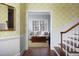 Elegant entryway featuring decorative wallpaper, a staircase, and a glimpse into a cozy living room at 3508 Cambridge Rd, Durham, NC 27707