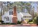 Charming two-story home with brick walkway, detailed brick chimney, manicured shrubs, and mature trees at 3508 Cambridge Rd, Durham, NC 27707