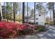 Beautiful two-story home featuring blue shutters, light siding, and flowering bushes nestled in a wooded landscape at 3508 Cambridge Rd, Durham, NC 27707