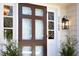Stylish front door with sidelights, transom window, and address number, flanked by small potted trees at 3508 Cambridge Rd, Durham, NC 27707