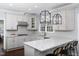 Modern kitchen with gray cabinets, granite countertops, stainless steel appliances, and decorative hanging lights at 3508 Cambridge Rd, Durham, NC 27707
