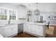Bright kitchen featuring white cabinets, stainless steel appliances, and a view of the outdoors at 3508 Cambridge Rd, Durham, NC 27707