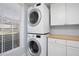 Efficient laundry area with stacked washer and dryer, bright window, and butcher block countertop at 3508 Cambridge Rd, Durham, NC 27707