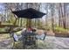 Outdoor patio with black metal table and chairs with a black umbrella at 3508 Cambridge Rd, Durham, NC 27707