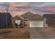 Charming single-Gathering home with a two-car garage and stone and siding exterior, enhanced by a colorful sunset at 358 E Painted Way Way, Clayton, NC 27527