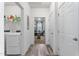 Hallway view with laundry room, and view to living room, featuring modern flooring and white doors at 358 E Painted Way Way, Clayton, NC 27527