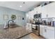 Granite countertops and stainless steel appliances in an updated kitchen with stylish tile backsplash at 358 E Painted Way Way, Clayton, NC 27527