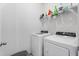 Clean laundry room featuring a white washer and dryer set with shelving above for storage at 358 E Painted Way Way, Clayton, NC 27527