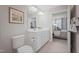 Well-lit bathroom featuring double vanity, tile floors, and a toilet; bedroom visible through door at 37 Artesa Ct, Fuquay Varina, NC 27526
