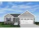 Charming single-Gathering home featuring stone accents, blue door, and an attached two-car garage at 37 Artesa Ct, Fuquay Varina, NC 27526