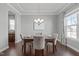 Bright dining room with hardwood floors, decorative trim, stylish chandelier, and window with patterned curtains at 4117 Bluff Oak Drive Dr, Cary, NC 27519