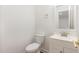 Well-lit half bathroom featuring a white toilet, vanity, and a simple, modern mirror at 464 Longfellow St, Fuquay Varina, NC 27526