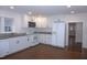 Open kitchen featuring white appliances, granite countertops, and wood flooring at 464 Longfellow St, Fuquay Varina, NC 27526