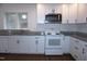 Close-up of updated eat-in kitchen with white appliances and granite countertops at 464 Longfellow St, Fuquay Varina, NC 27526