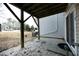 View from underneath back porch shows the side of a building and a pebble-filled yard at 4905 Briarstone Ct, Raleigh, NC 27610