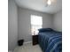 Bright bedroom with a window, simple decor, and a cozy ambiance with a navy blue bedspread at 4905 Briarstone Ct, Raleigh, NC 27610