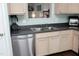 The kitchen area featuring a stainless steel dishwasher, double sink, and light wood cabinets at 4905 Briarstone Ct, Raleigh, NC 27610