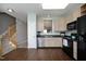 A view of the kitchen with stainless steel appliances, wood cabinets, and wood flooring next to the stairway at 4905 Briarstone Ct, Raleigh, NC 27610