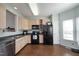 An open kitchen offers wood cabinets, stainless steel dishwasher, black appliances, and hardwood floors at 4905 Briarstone Ct, Raleigh, NC 27610