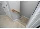 Overhead view of carpeted stairs with a wooden handrail leading to a landing with a white door at 4905 Briarstone Ct, Raleigh, NC 27610