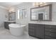 Bright bathroom featuring a standalone tub, dual vanities, and marble floors at 5600 Abbey Grace Ln, Wake Forest, NC 27587