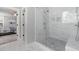 Bathroom with a glass shower, white marble tiles, and a glimpse into the main bedroom at 5600 Abbey Grace Ln, Wake Forest, NC 27587