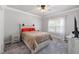 Neutral bedroom with gray carpet, a window view, and a wooden accent headboard at 5600 Abbey Grace Ln, Wake Forest, NC 27587