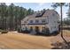 Expansive home exterior with a long driveway, and a basketball hoop, surrounded by mature trees and lush greenery at 5600 Abbey Grace Ln, Wake Forest, NC 27587