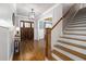 Welcoming foyer featuring hardwood floors, a striking staircase, and a solid wood front door at 5600 Abbey Grace Ln, Wake Forest, NC 27587