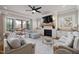 An open-concept living room boasts a fireplace, large tv, light gray furniture and a screened in porch at 5600 Abbey Grace Ln, Wake Forest, NC 27587