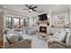 An open-concept living room boasts a fireplace, large tv, light gray furniture and a screened in porch at 5600 Abbey Grace Ln, Wake Forest, NC 27587