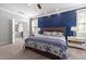 Primary bedroom with a blue accent wall and decorative bedside tables with carpeted floors at 5600 Abbey Grace Ln, Wake Forest, NC 27587