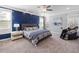 Primary bedroom with a blue accent wall, carpeted floors, and massage chair at 5600 Abbey Grace Ln, Wake Forest, NC 27587