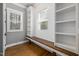 This mud room features a built-in bench, shelves, white shiplap and hardwood floors at 5600 Abbey Grace Ln, Wake Forest, NC 27587