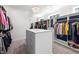 Bright walk-in closet with custom built-ins, drawers, carpeted floors, and plenty of storage space at 5600 Abbey Grace Ln, Wake Forest, NC 27587