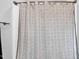 Close up of a white shower curtain with a unique geometric pattern in a well-lit bathroom at 59 N Clearbrook Ct, Angier, NC 27501