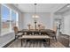 Elegant dining room features a large wooden table with seating for eight under a modern chandelier at 59 N Clearbrook Ct, Angier, NC 27501