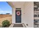 Close-up of a stylish navy front door adorned with a floral wreath and a sleek door handle at 59 N Clearbrook Ct, Angier, NC 27501
