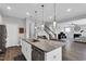 Kitchen island with sink, dishwasher, granite countertops, and seating showcases the open-concept living space at 59 N Clearbrook Ct, Angier, NC 27501