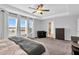 Inviting main bedroom with a tray ceiling, ceiling fan, and large windows offering ample natural light at 59 N Clearbrook Ct, Angier, NC 27501