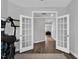 View through French doors into a home office, complete with a gaming setup and modern decor at 59 N Clearbrook Ct, Angier, NC 27501