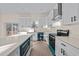 Modern kitchen featuring white cabinets, stainless steel appliances, and a spacious island with a quartz countertop at 612 Lakeview Dr, Raleigh, NC 27603