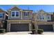 Street view of gray home featuring two-car garage, manicured shrubbery and tidy sidewalk at 621 Rockcastle Dr, Cary, NC 27519