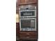 Built-in stainless steel oven and microwave combo with dark brown cabinets at 621 Rockcastle Dr, Cary, NC 27519