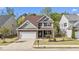 Beautiful two-story home with a manicured lawn, stone accents, and attached garage, bathed in natural light at 69 Florence Dr, Clayton, NC 27527