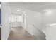 Upstairs hallway with neutral carpet, white walls and trim, and an open staircase at 69 Florence Dr, Clayton, NC 27527