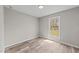 Bright bedroom features light hardwood floors, a large window, and neutral-colored walls at 711 Wheat Mill Rd, Durham, NC 27704