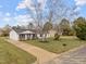 Aerial view of a cozy home with a well-manicured lawn, surrounded by mature trees and a welcoming driveway at 711 Wheat Mill Rd, Durham, NC 27704