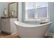 Bright bathroom featuring a modern soaking tub, vanity with granite countertop, and large window at 714 Waterford Lake Dr, Cary, NC 27519