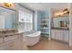 Luxurious bathroom with freestanding tub, granite vanity, and a decorative shelving unit at 714 Waterford Lake Dr, Cary, NC 27519